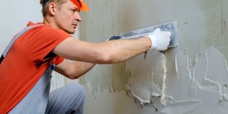 Travailleur enduit un mur