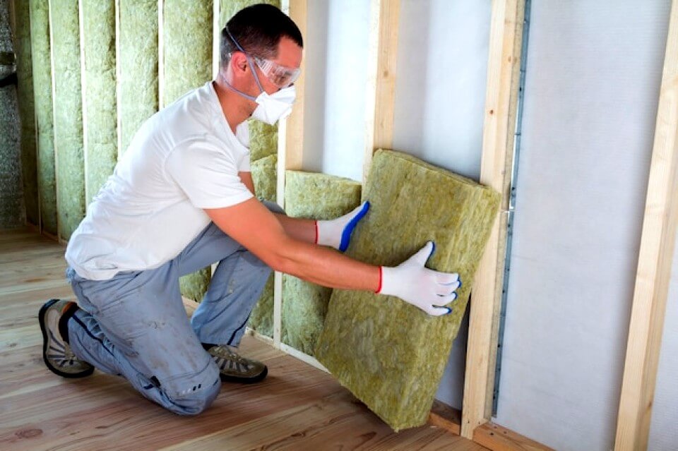 Travailleur isolant un mur intérieur