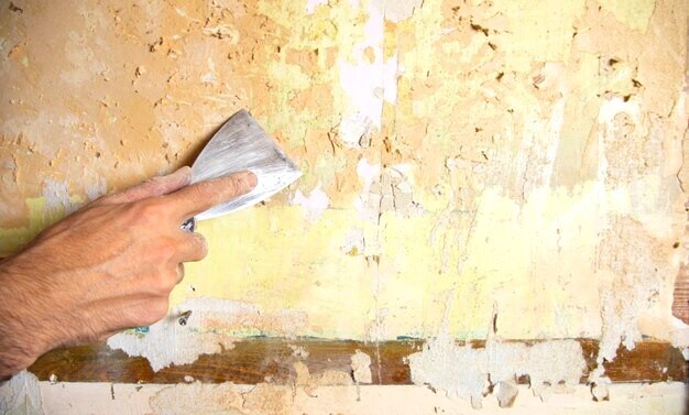 Enlever du vieux papier peint sur un mur abimé