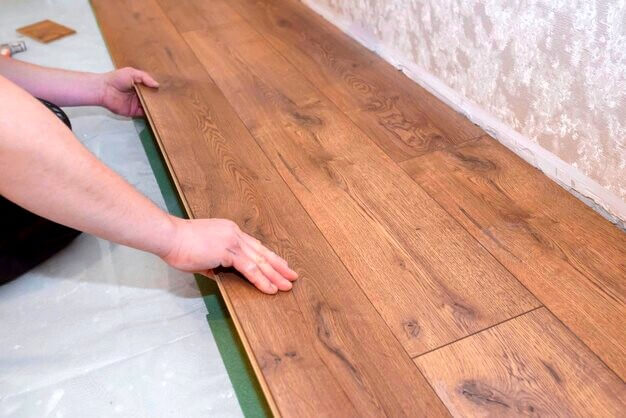 travailleur-pose-parquet-bois-sur-carrelage