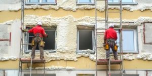 Des ouvriers de la construction ravalent la façade d'une maison