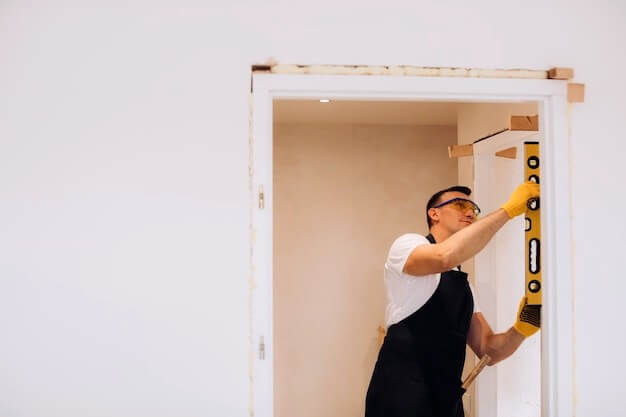Homme remplaçant une porte intérieure