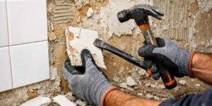 Travailleur enlève de la faience sur du placo