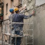 Ouvriers sur échafaudage réalisant le ravalement d'une façade d'immeuble collectif