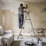 Artisan appliquant une sous-couche sur un plafond en plâtre