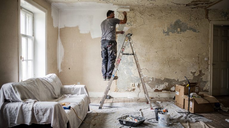 Artisan appliquant une sous-couche sur un plafond en plâtre